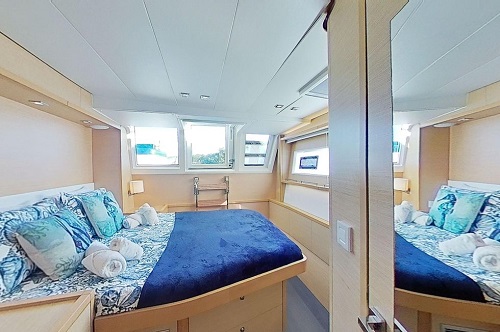 cabine a bord du catamaran à voiles  Tiger Lily avec des draps bleus